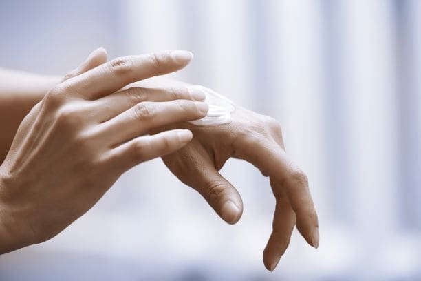 A person hands applying the cream